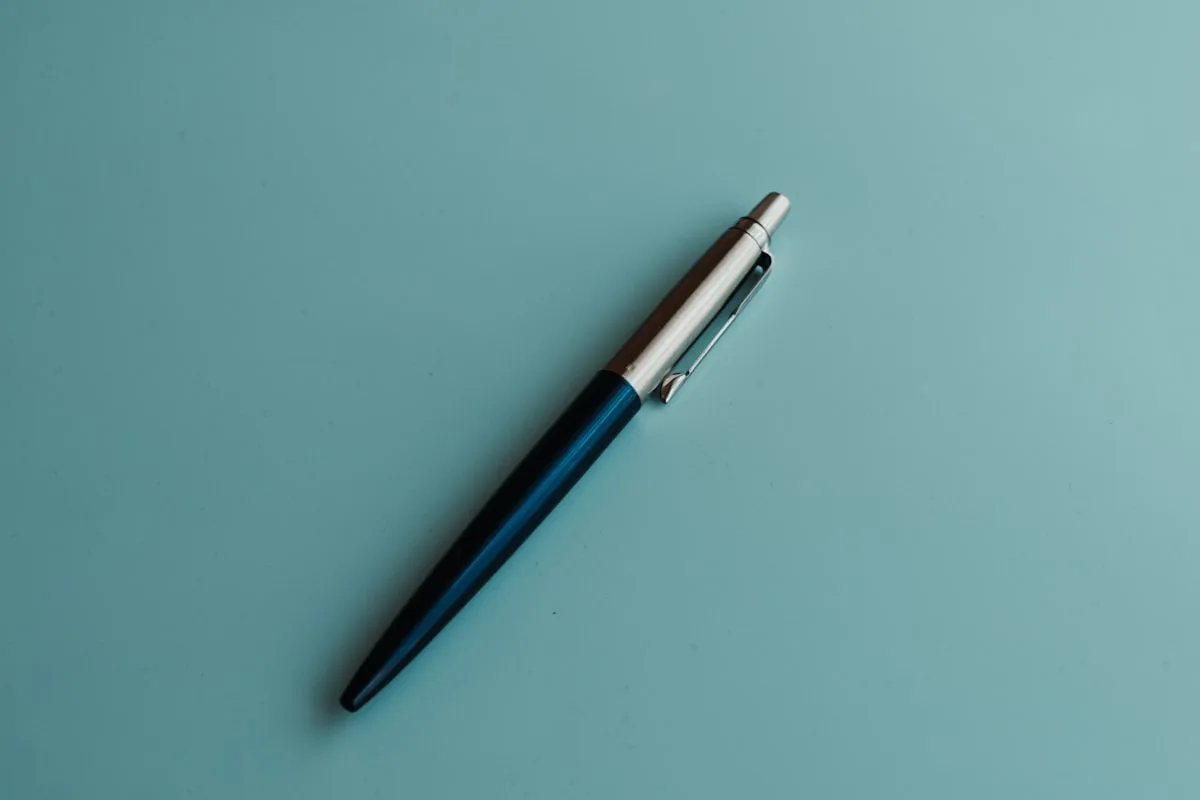 Assorted colorful pens scattered on a white desk surface