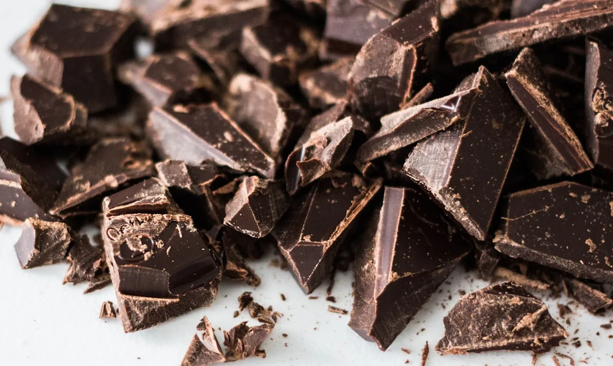 Dark chocolate squares arranged on a white surface, rich and glossy