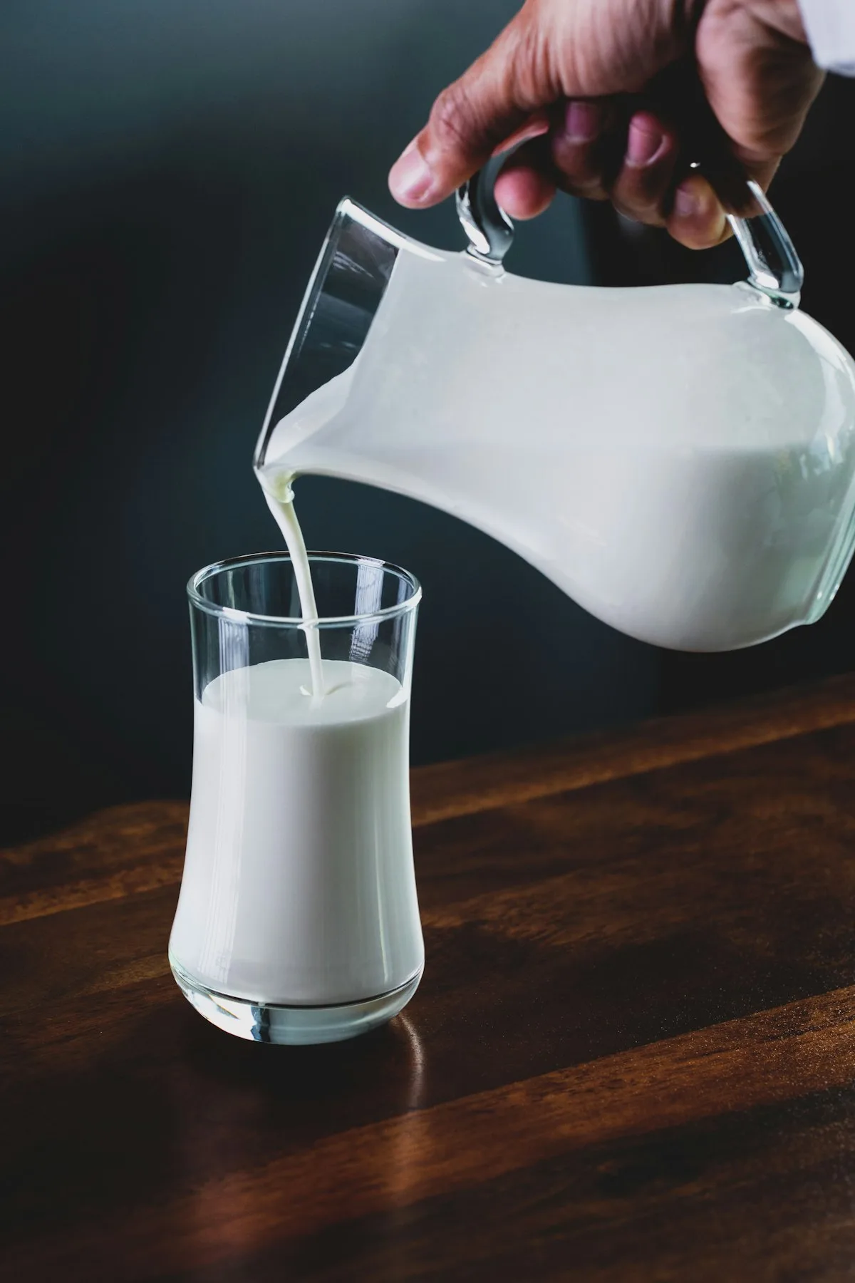 A glass of cold milk on a clean surface, condensation on the outside of the glass