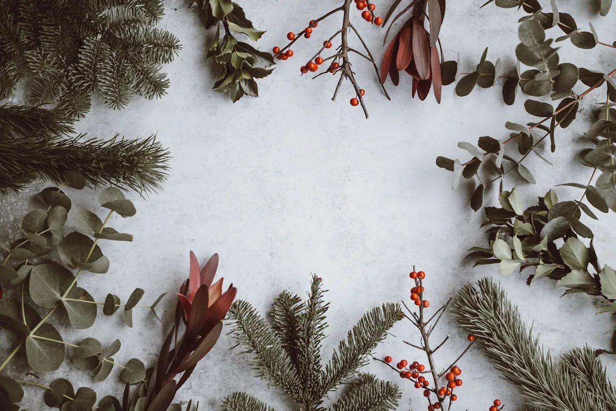 Snow covered Christmas tree branches with warm bokeh lights in background