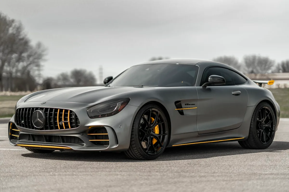 Sleek silver luxury car on a wet road at dusk with dramatic lighting