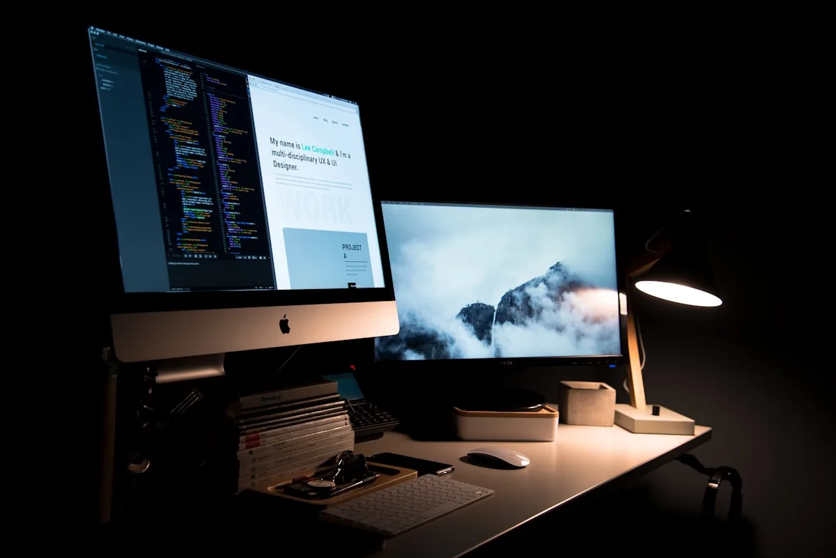 Person typing on a laptop at a minimalist desk with a coffee cup and notebook
