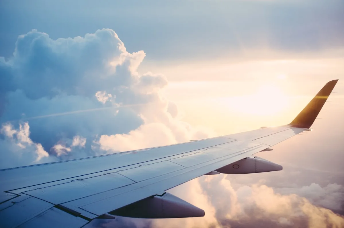 Commercial airplane on a runway at dusk with golden light and clouds