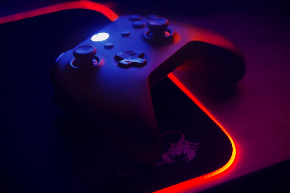 Xbox controller on a dark textured surface with neon accent lighting